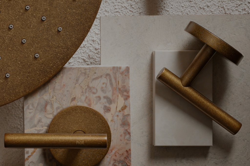 A flatlay featuring Nero's Tumbled Antique Brass tapware with some tile and stone.